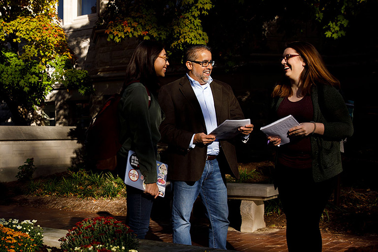 A group of IU staff members talking outside on a sunny autumn day
