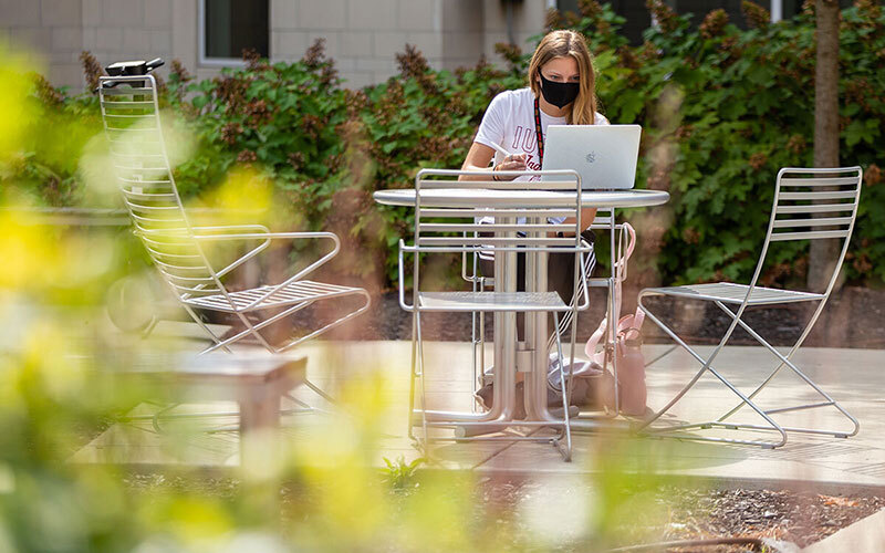 IU student working on laptop outside