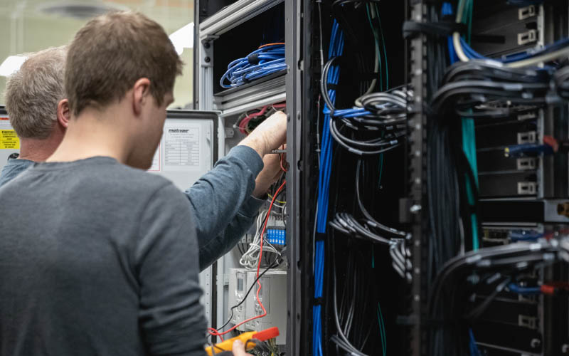 Two people working on a server rack